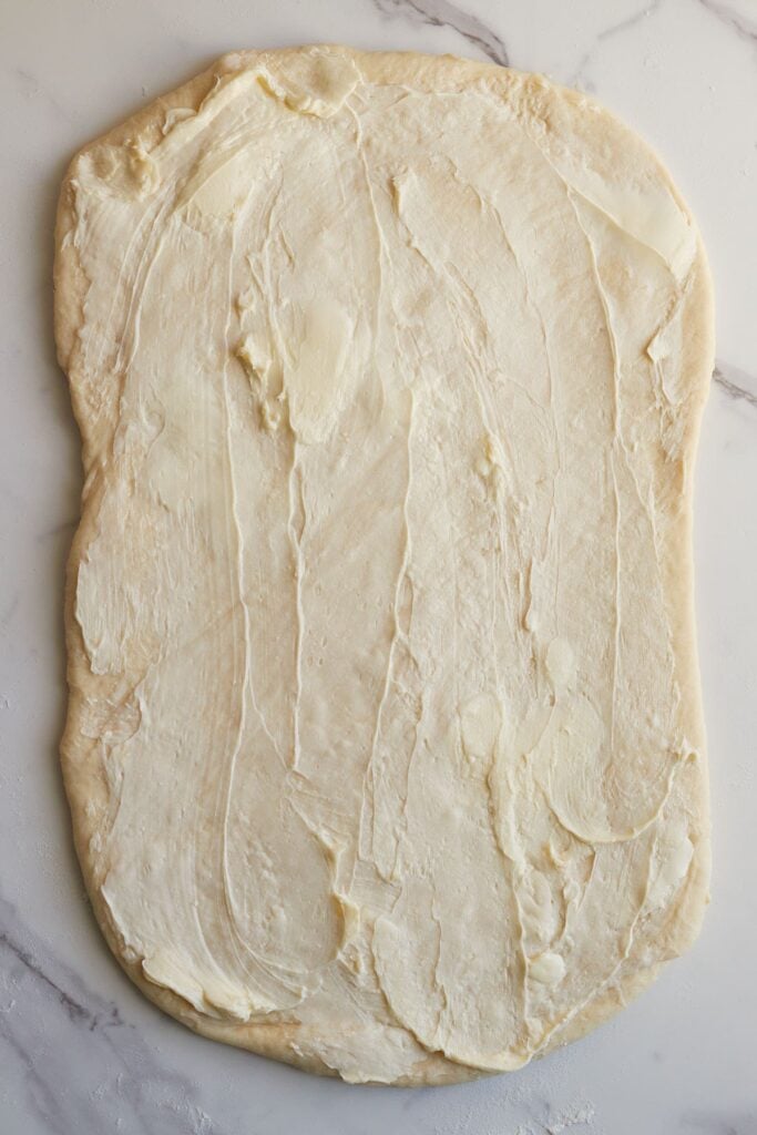 Softened butter added to sourdough cinnamon roll dough.