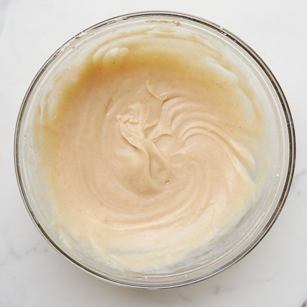 Brown butter cream cheese frosting in a clear bowl.