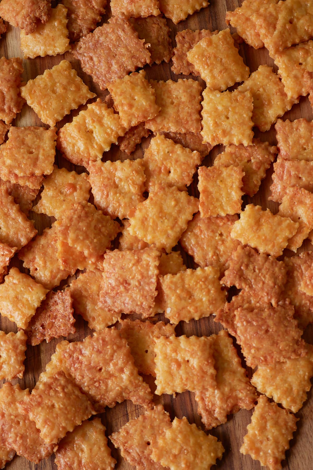 Sourdough Cheez It Crackers scattered on a wooden board.
