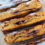 Slices of Sourdough Pumpkin Focaccia with icing on brown parchment paper.
