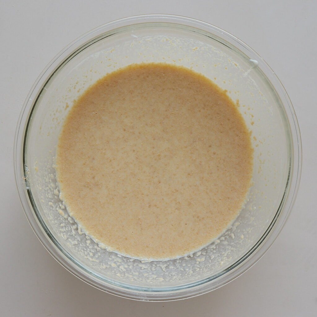 Wet ingredients for sourdough apple muffins mixed together in a clear bowl.