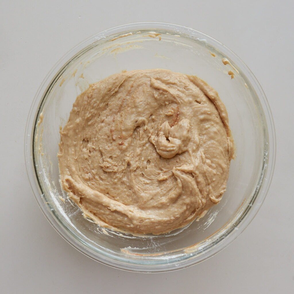Dry ingredients for sourdough apple muffins mixed together in a clear bowl.