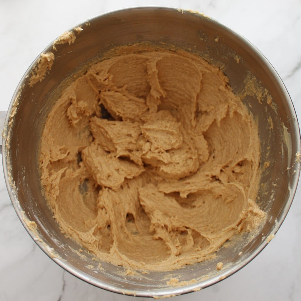 Wet ingredients added in a metal bowl for cookie butter sourdough cookies.