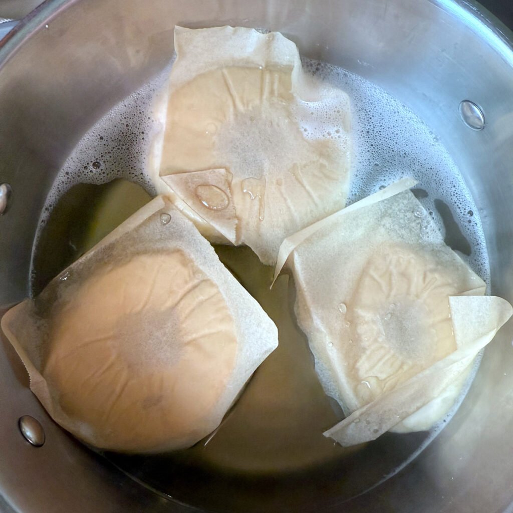 Sourdough Bagels in a pot of boiling water with baking soda.