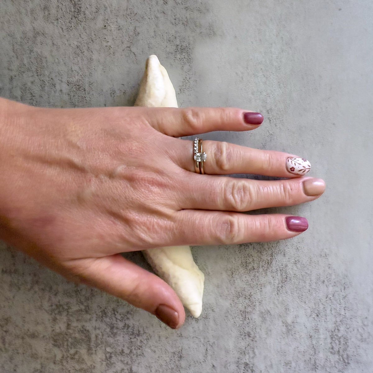 Hand rolling out sourdough breadstick dough into a long log shape.