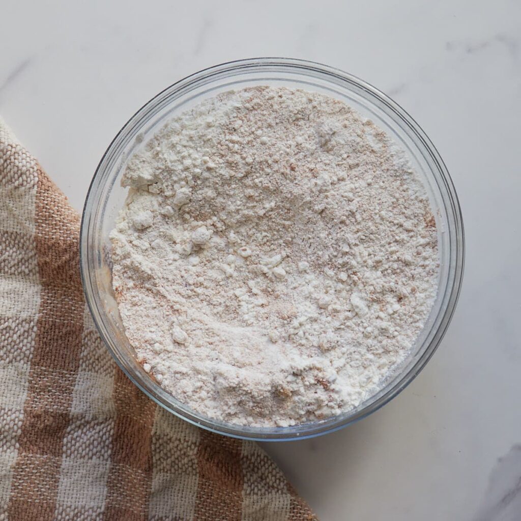 Dry ingredients for Sourdough Pumpkin Pancakes mixed in a clear bowl.