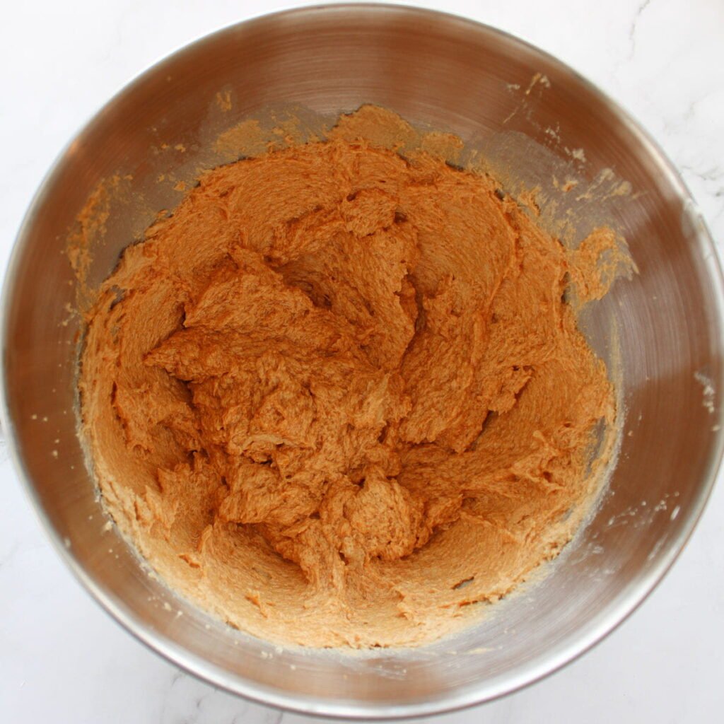 Wet ingredients added to cookie dough for Sourdough Pumpkin Snickerdoodles in a metal bowl.