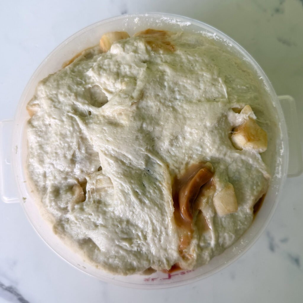 Caramel Apple Sourdough Focaccia dough in a round container after the first rise.