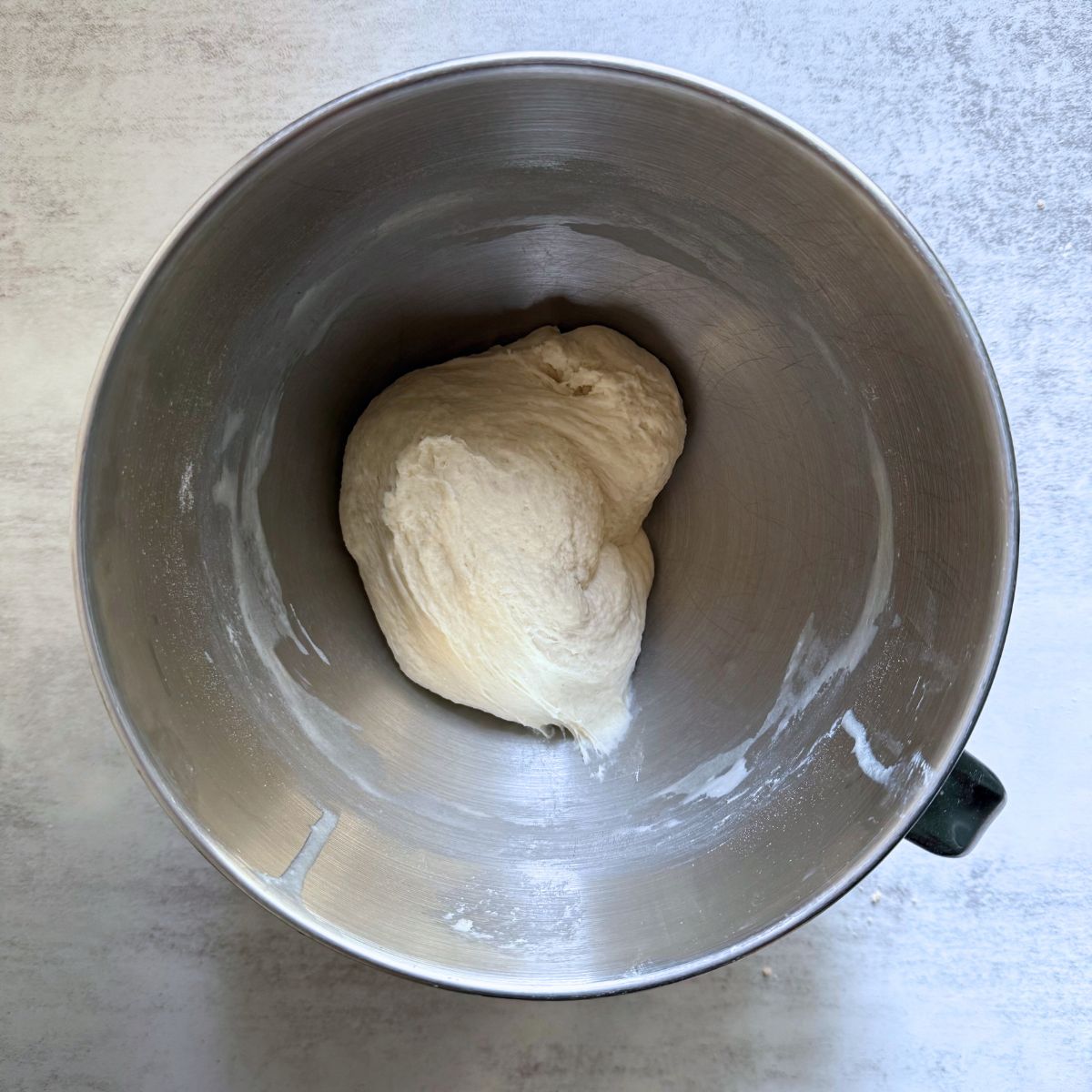 Sourdough breadstick dough in a metal stand mixer bowl.