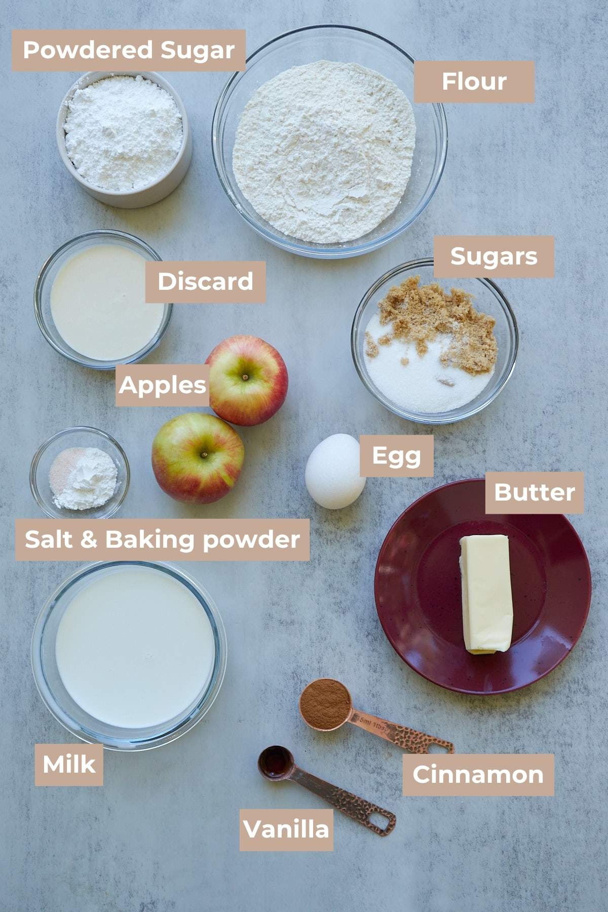 Ingredients for Sourdough Apple Fritter Bread in clear bowls on a gray background.