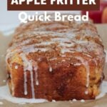 A loaf of Sourdough Apple Fritter Bread with vanilla icing on top on a piece of brown parchment paper.