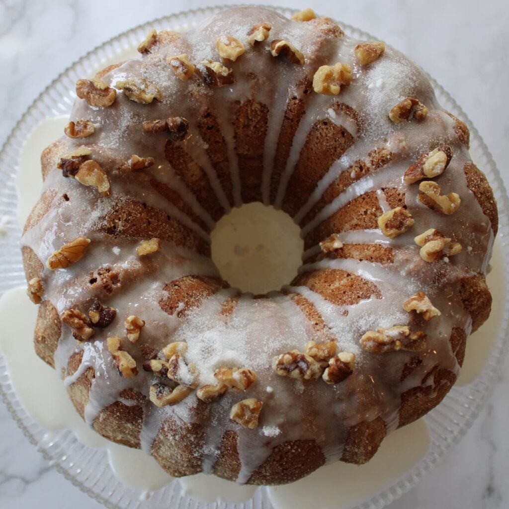 Icing drizzle and walnuts on top of the freshly baked sourdough coffee cake.