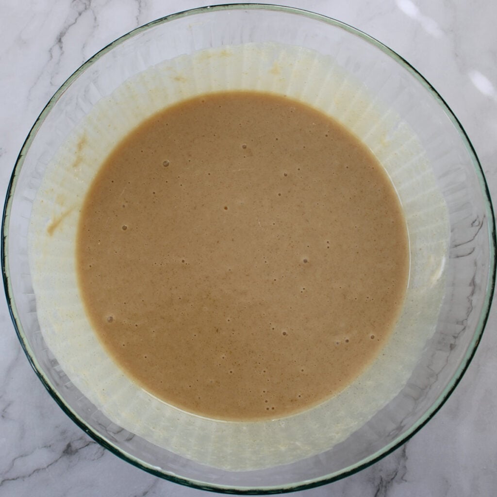 Remaining wet ingredients added to sourdough coffee cake batter in a clear bowl.