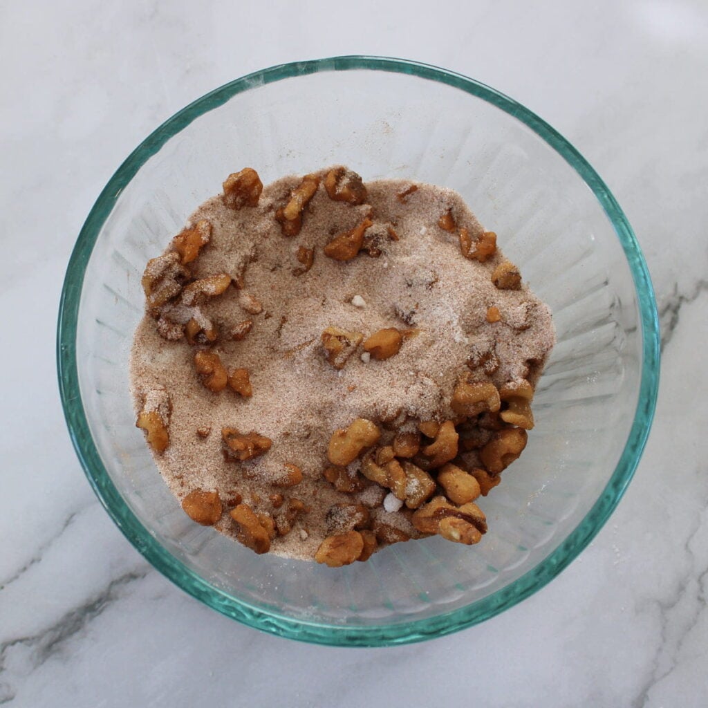 Sugar, cinnamon and walnuts combined in a small bowl for sourdough coffee cake.