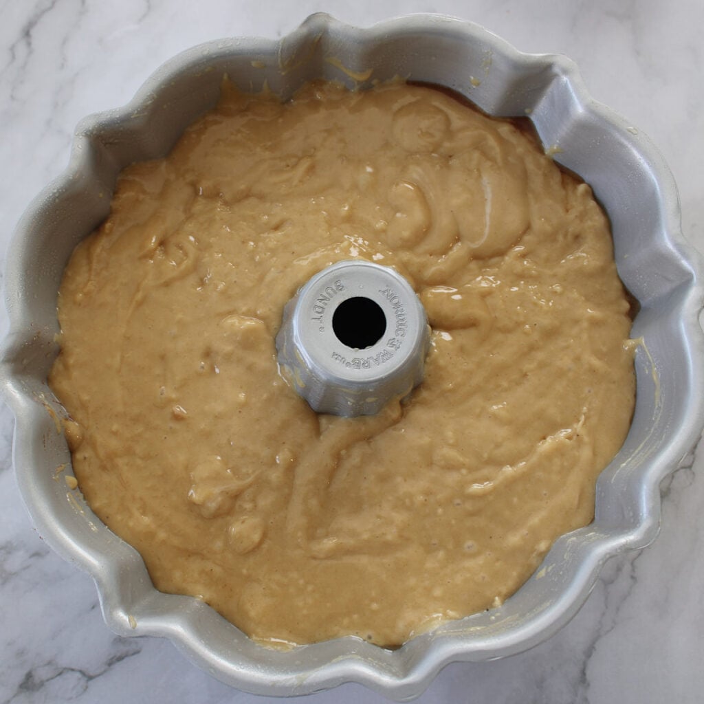 Second layer of batter added to bundt pan for sourdough coffee cake.