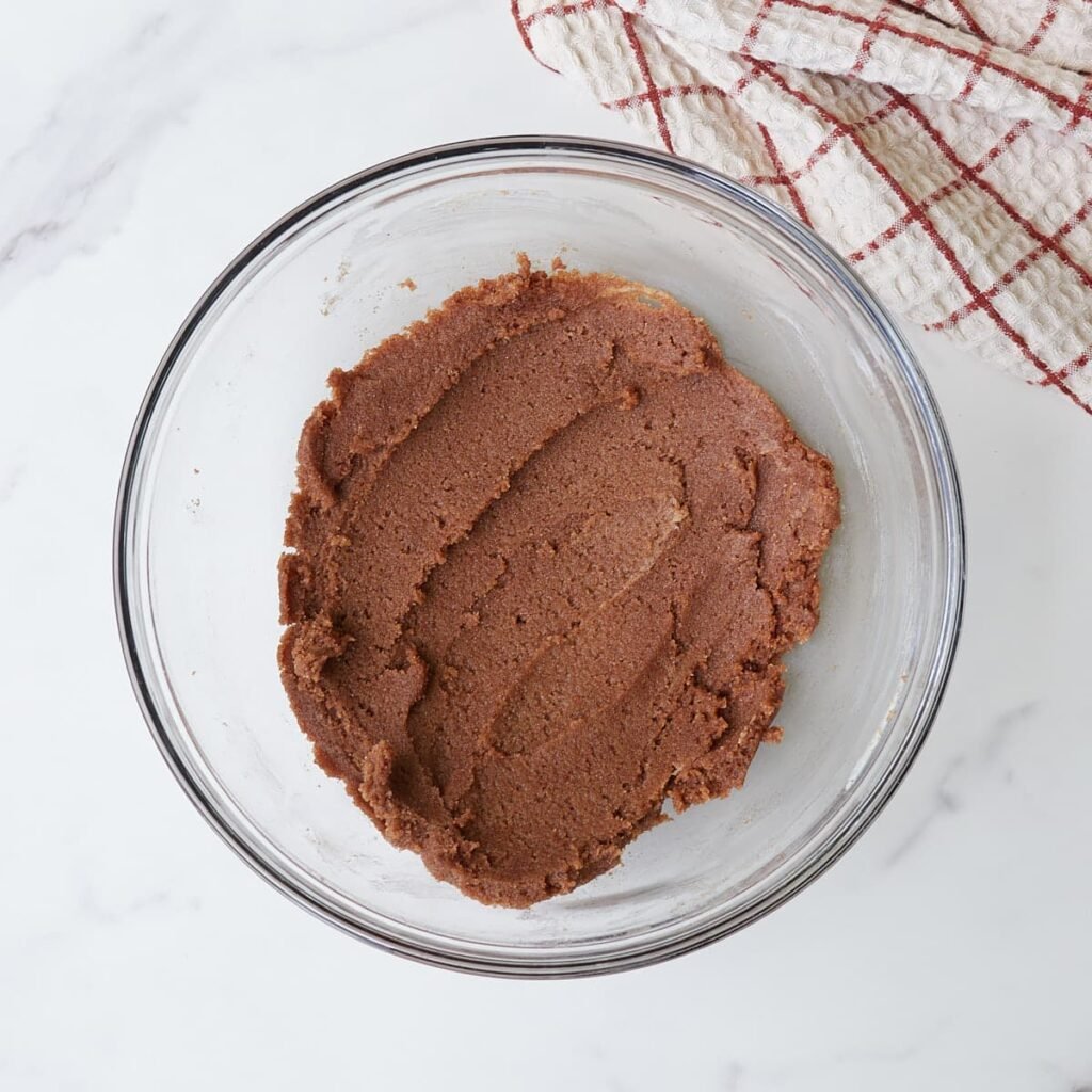 Filling for sourdough pumpkin cinnamon rolls mixed in a small clear bowl.