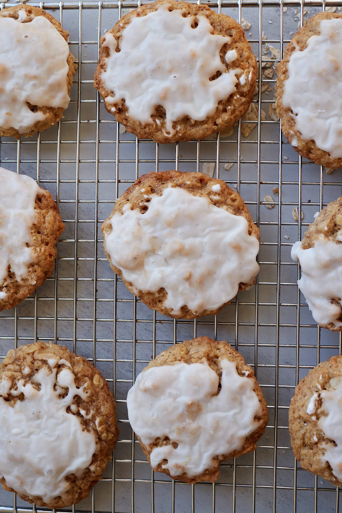 Sourdough Oatmeal Cookies with a vanilla bean glaze on a wire rack.