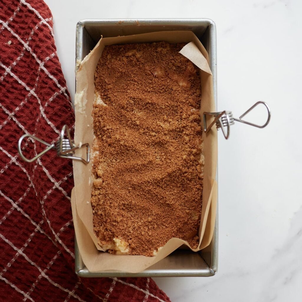 The first layer of Sourdough Apple Fritter Bread and cinnamon sugar mixture.