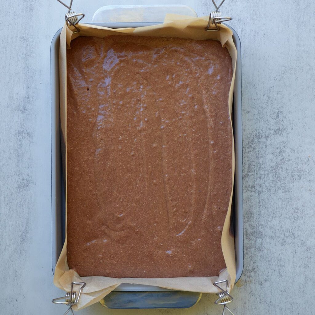 Batter for Sourdough Chocolate Cake added to a parchment lined 9x13 baking dish.