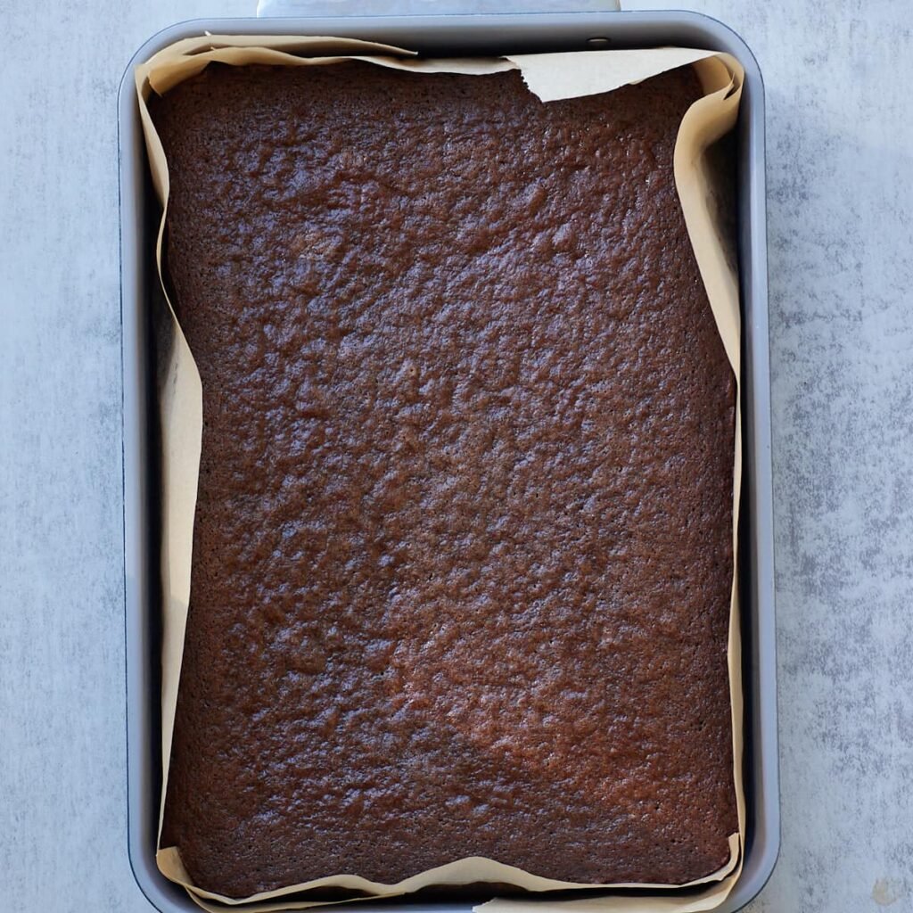 Freshly baked Sourdough Chocolate Cake in a 9x13 pan lined with parchment paper.