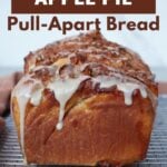 Loaf of sourdough apple pie pull apart bread with vanilla glaze on a wire rack.
