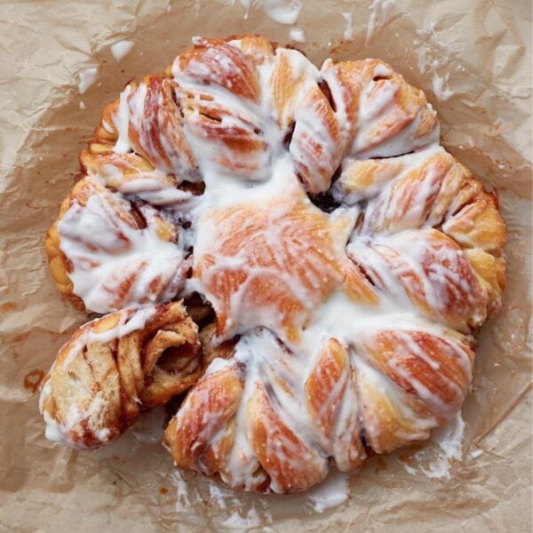 Sourdough Cinnamon Star Bread with cream cheese icing, with a section pulled off.