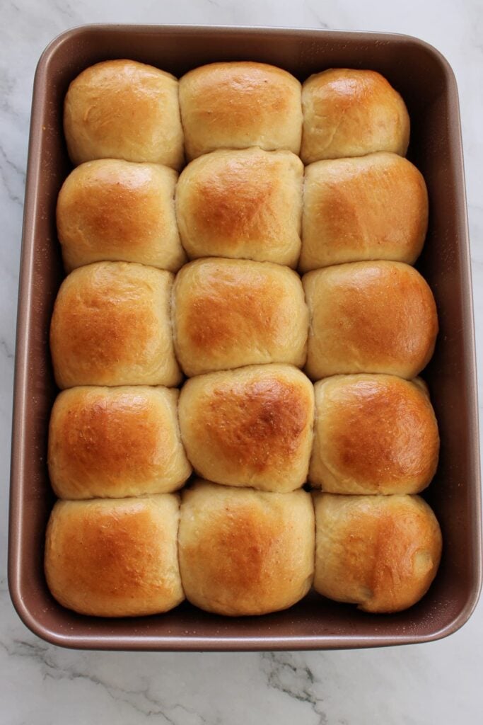Freshly baked sourdough discard Hawaiian rolls in a 9x13 pan.
