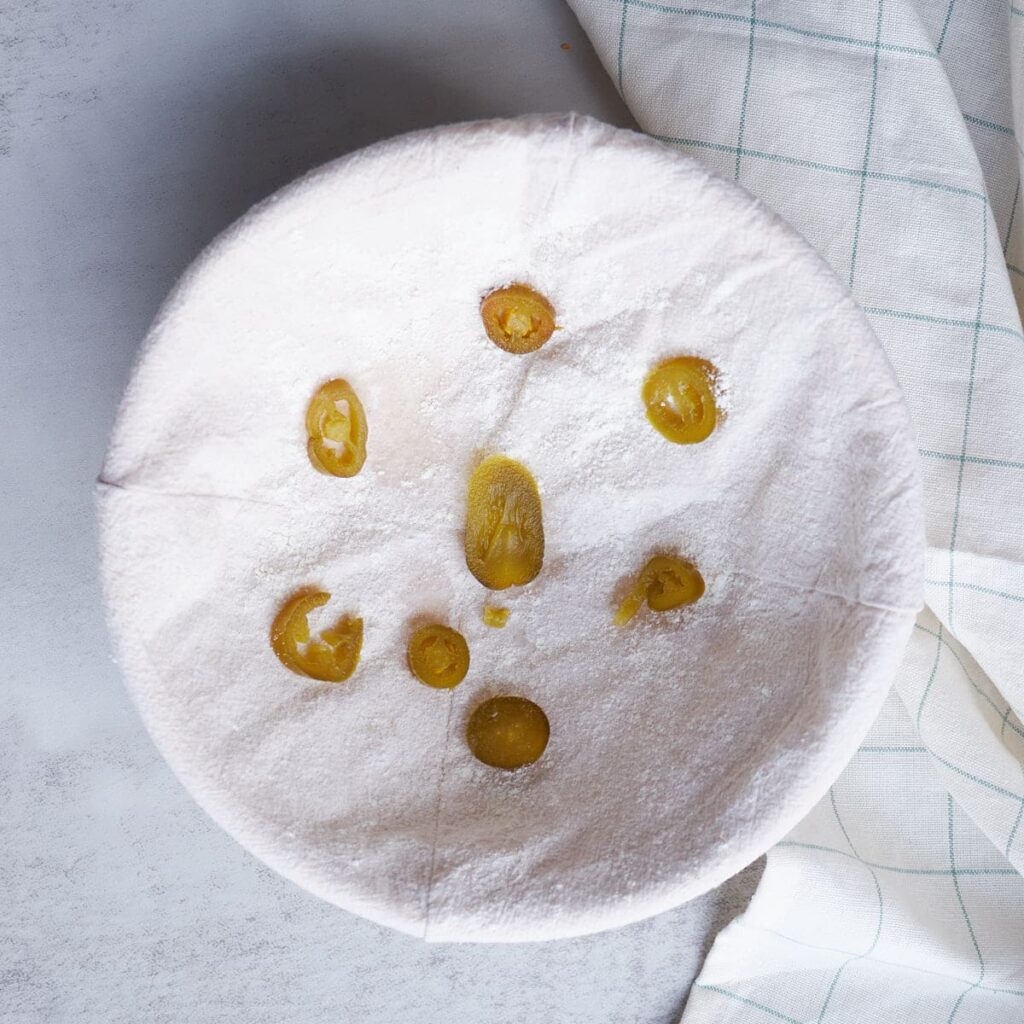 Jalapenos placed on top of the banneton basket.
