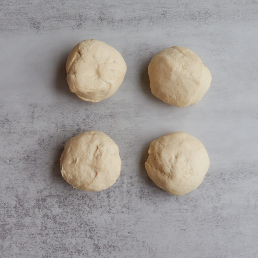 Dough for sourdough cinnamon star bread divided into four dough balls.