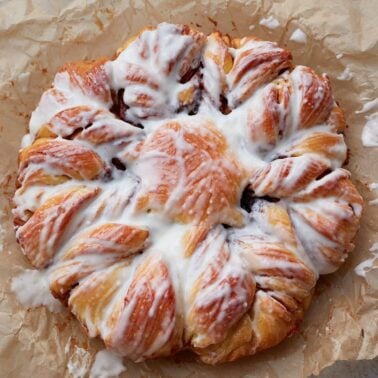 Cream cheese frosting added to freshly baked sourdough cinnamon star bread.