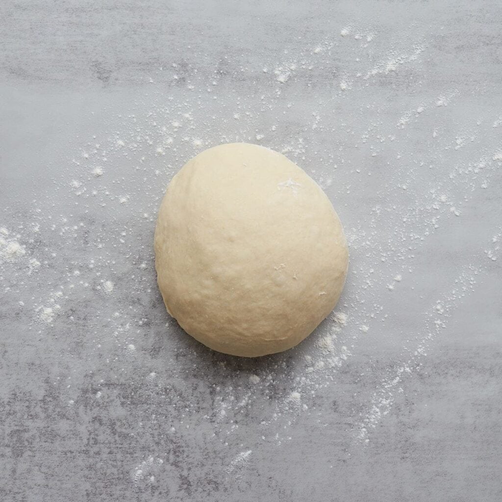 Dough for sourdough discard cinnamon rolls on a lightly floured surface.