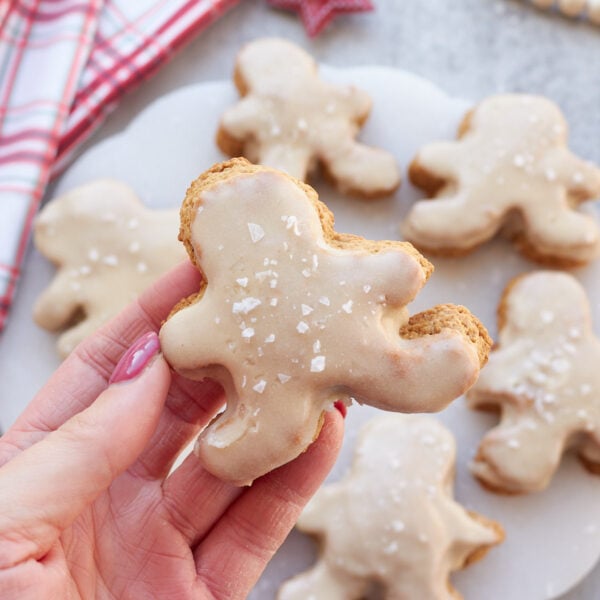 A hand holding a sourdough gingerbread man shaped scone.