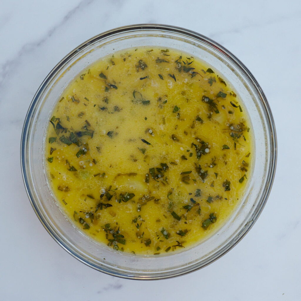 Melted butter with herbs and vegetables for sourdough stuffing.