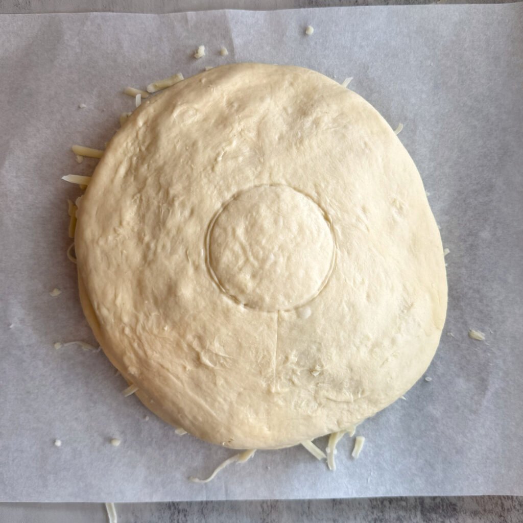 A circle added to the center of Cheesy Sourdough Star Bread dough after adding the filling.