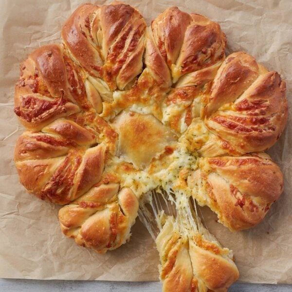 Section of Cheesy Sourdough Star Bread pulled out with a cheese pull.