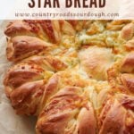 Freshly baked Cheesy Sourdough Star Bread on parchment paper.