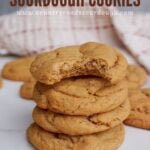 Four peanut butter sourdough cookies stacked on top of each other with a bite taken out of the top cookie.