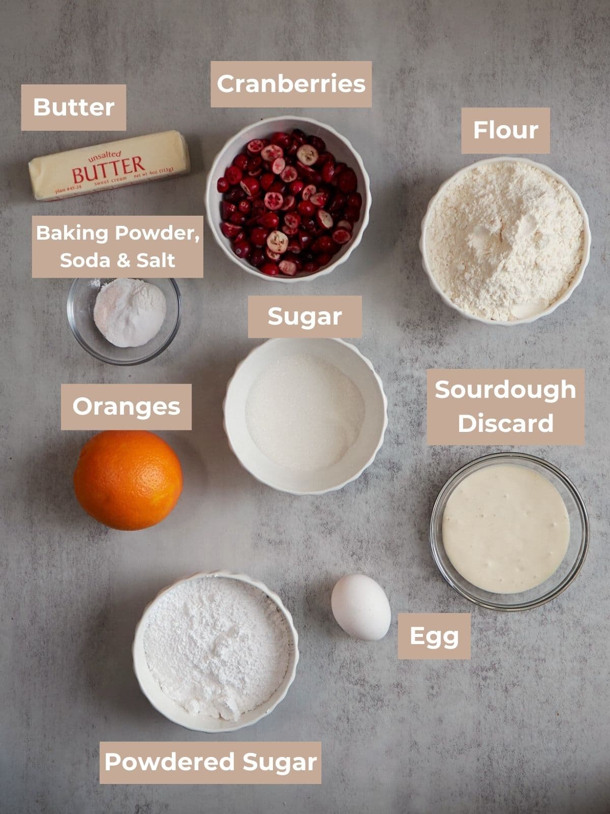 cranberry orange sourdough scone ingredients in bowls on a gray board. 