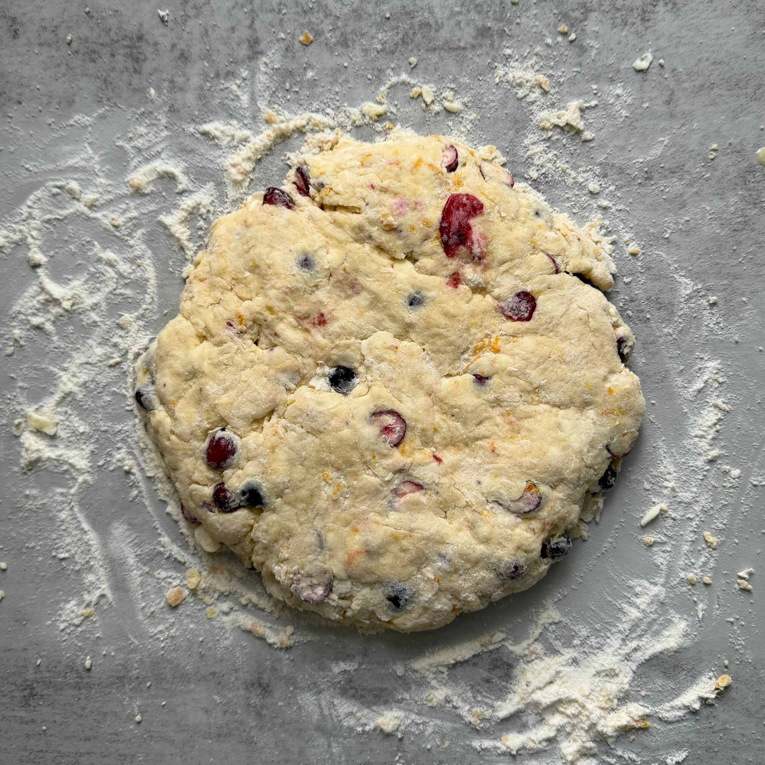 Sourdough cranberry orange sourdough scones dough in a round 8 inch disc.