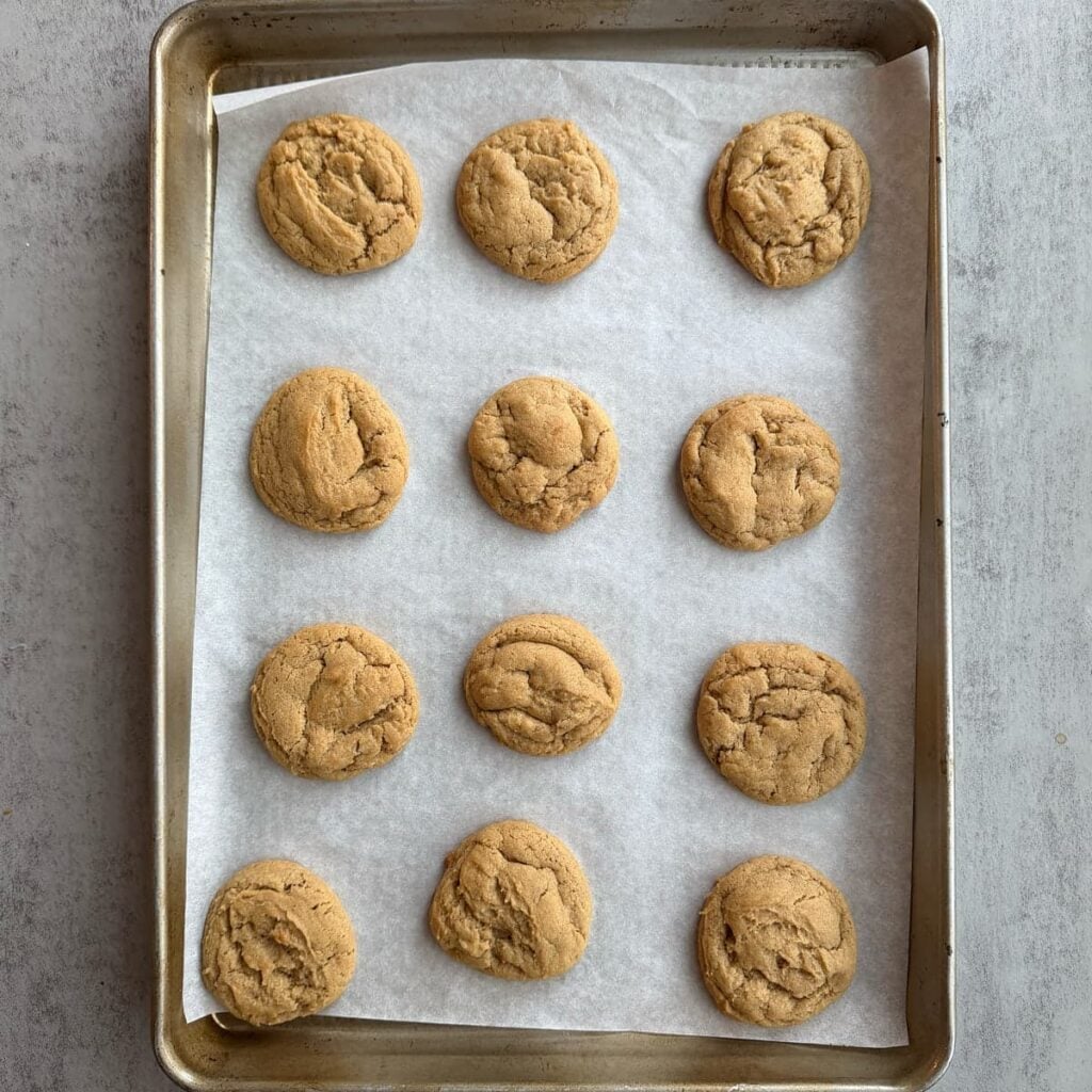 Freshly baked sourdough peanut butter cookies on a sheet pan.