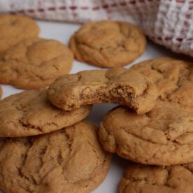 Sourdough Peanut Butter Cookies piled on top of each other with a bite taken out of the top cookie.