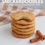 Sourdough Snickerdoodle Cookies stacked on top of each other next to cinnamon sticks.