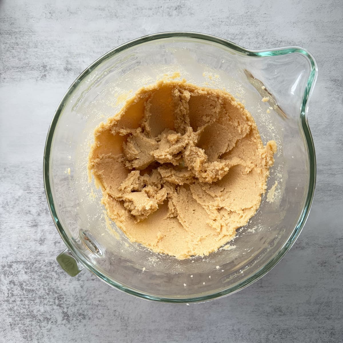 Butter and sugars creamed together in a clear bowl.