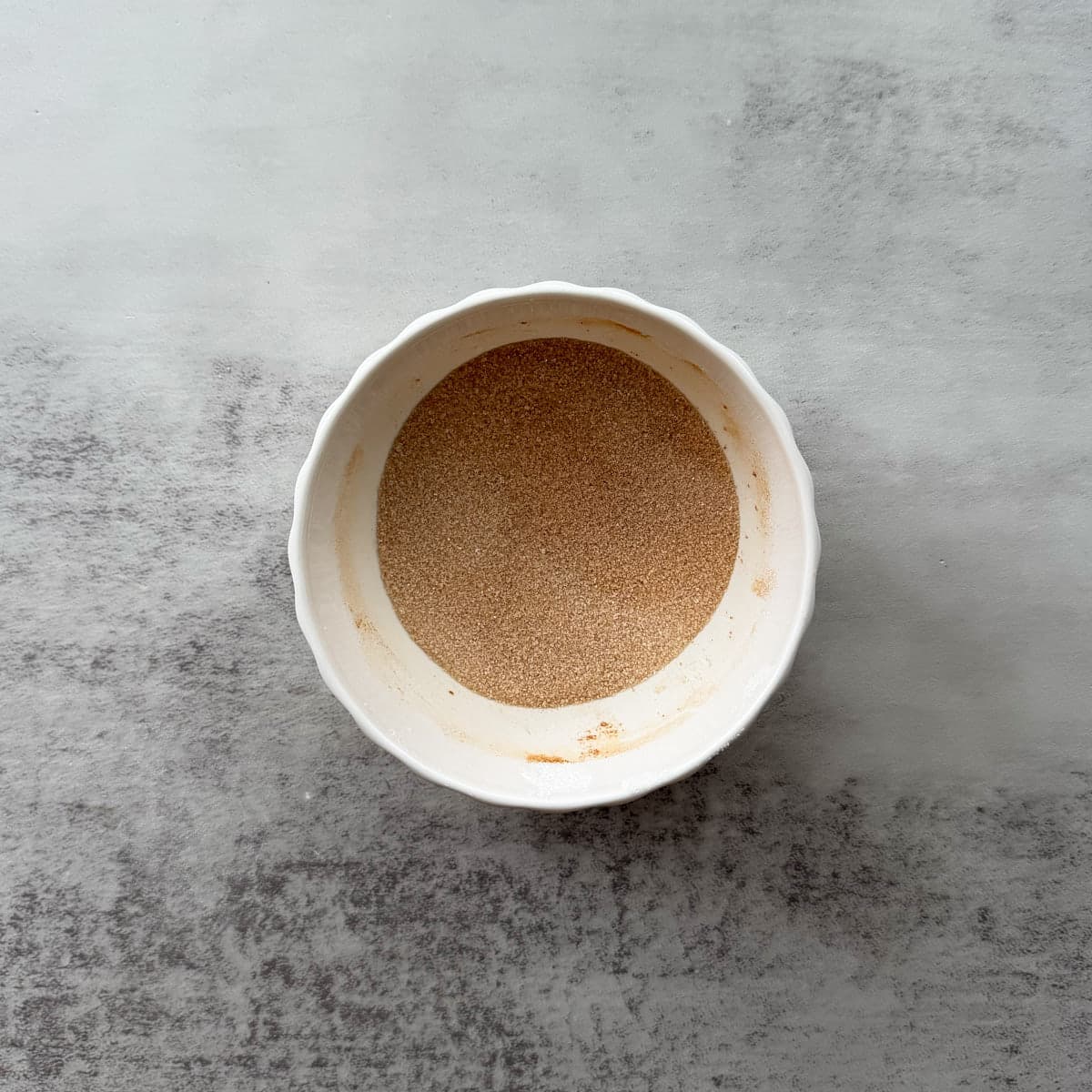 Small white bowl of cinnamon and sugar