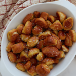 Pinterest pin of close up of sourdough discard pretzel bites in a white bowl on a counter and a towel in the top left corner.