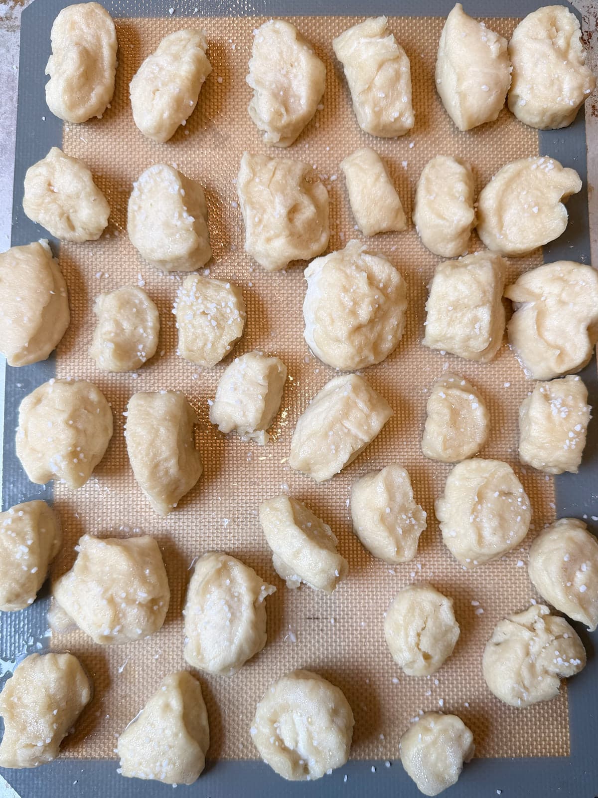 Sourdough discard pretzel bites after the baking soda bath, arranged on a prepared baking sheet.