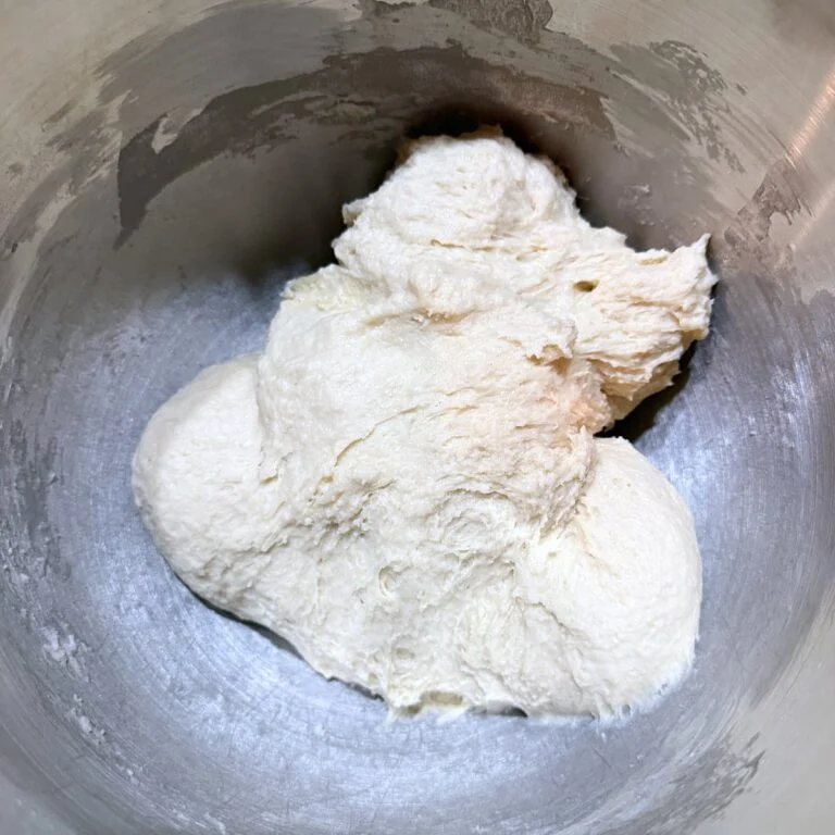 Sourdough monkey bread dough in a metal kitchen aid mixing bowl.