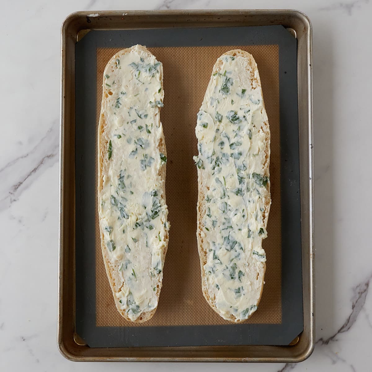 Two slices of sourdough french bread with garlic butter spread on top. 