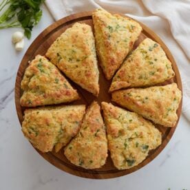 eight sourdough garlic bread scones arranges on a decorative tray.