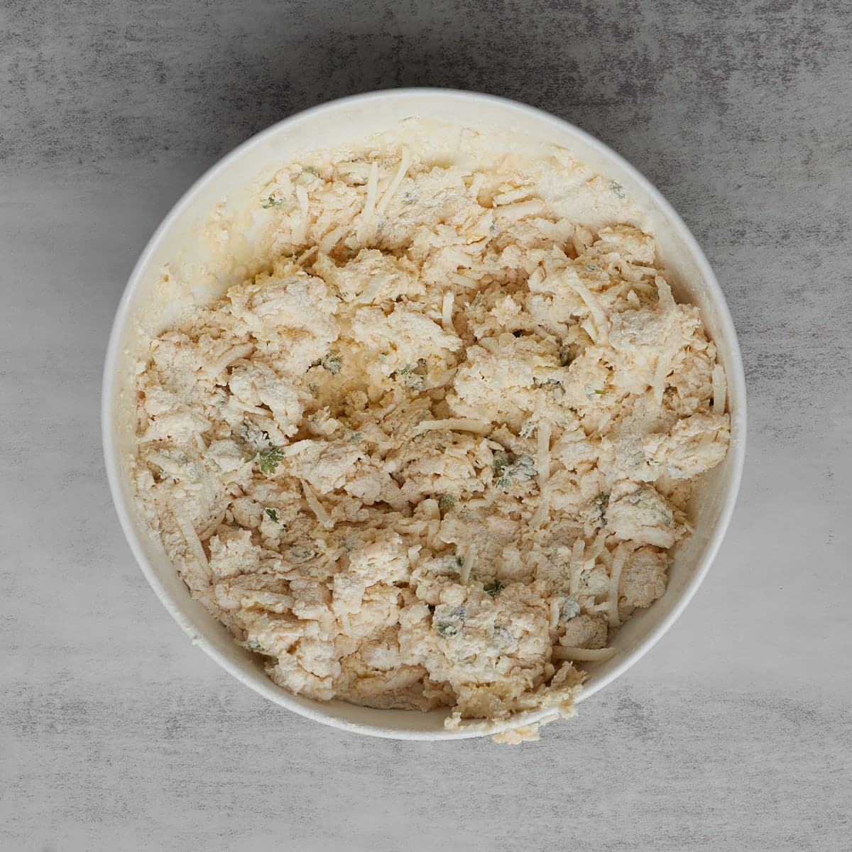 bowl of wet and dry ingredients combined for garlic scones.